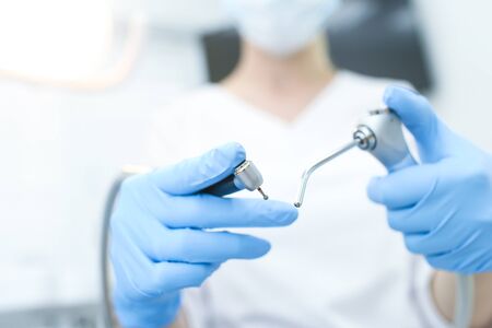 Closeup of instruments in hands of doctor in white mask. Selective focusの写真素材