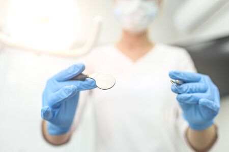 Closeup of dental mirror and dental probe in hands of doctor. Selective focus.の写真素材
