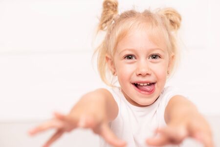 Closeup of blond young girls face fooling around, smile and laugh. Selective focusの写真素材