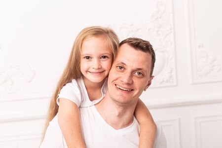 Little blond girl hugs her father and smile at fathers dayの写真素材