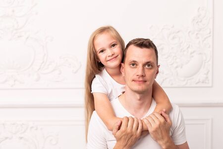Little blond girl hugs her father and smile at fathers dayの写真素材