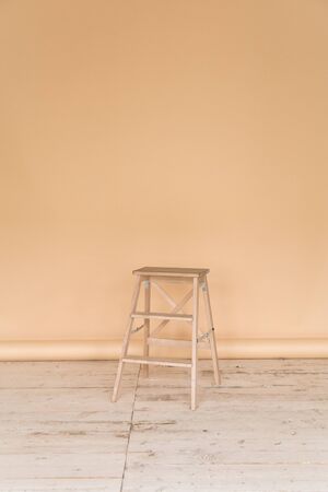 The working space of the photo studio with a beige paper background and chair.の写真素材