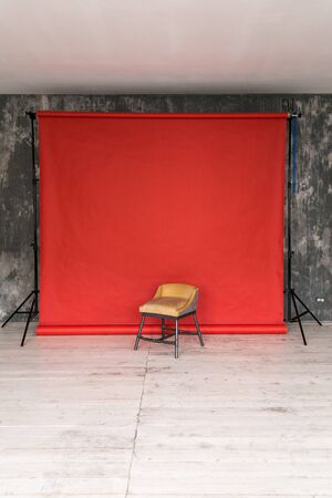 The working space of the photo studio with a red paper background and chairの写真素材