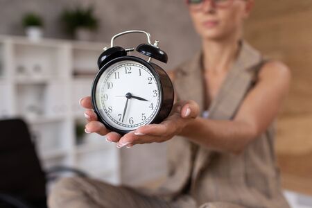 Closeup of mechanical clocks in hands of young blond womanの写真素材