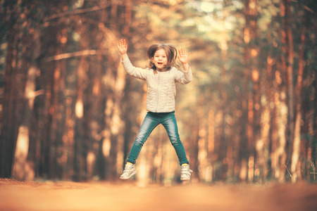 Little girl jumping and having fun outdoorsの写真素材