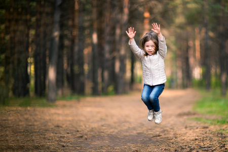 Little girl jumping high in air at parkの写真素材