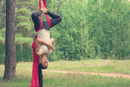 Young woman practicing fly yoga asana outdoors. Health, sport, yoga conceptの写真素材