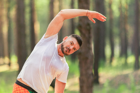 Man runner training. Male athlete stretching muscles at the park. Healthy, fitness, wellness...