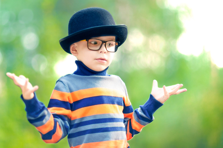 I Dont Know. Funny liittle boy wearing a hat and glasses confused.の写真素材