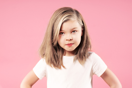 Portrait of a little serious blonde girl over pink background, close upの写真素材