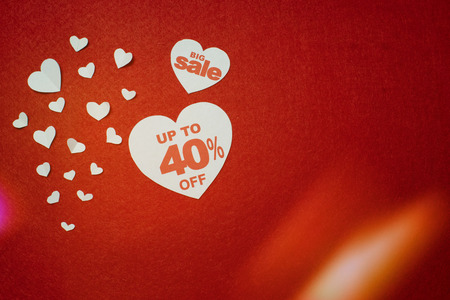 Symbol of heart for big sale with 40 percent next to other smaller white hearts on the red background. Discount promotionの写真素材