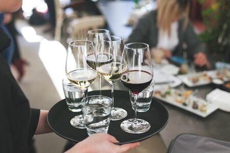 waitress at restaurant serving red and white wine