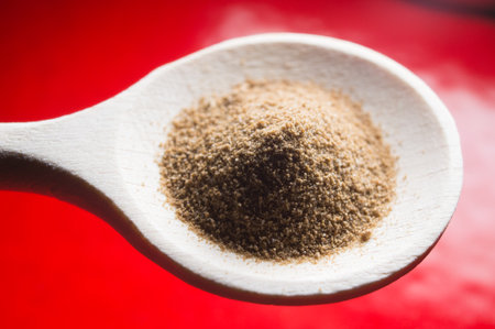 agave sugar in a wooden spoon on red background
