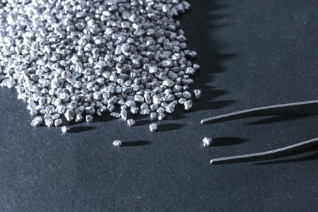 pile of small silver pieces displayed on dark background