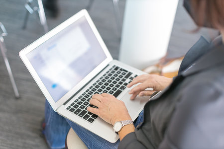 closeup of woman using a laptop taking notes during a seminar presentation eventの写真素材
