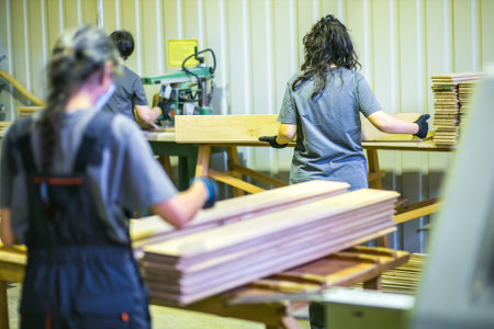 female workers working with planks in wood processing factory