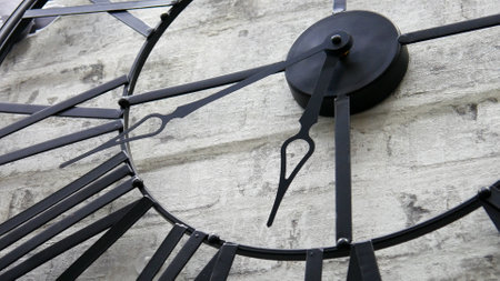 Close-up of a big iron decorative clock hanging on the wall
