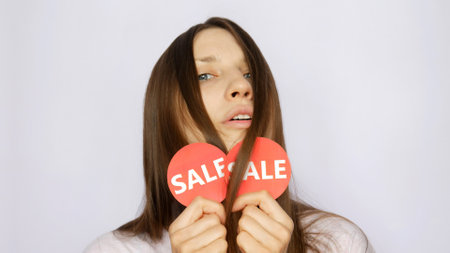 A passion girl holding two red round signs with the word SALE in her hands
