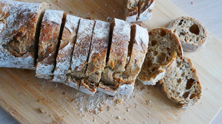 A beautiful sliced baguette on a wooden cutting board