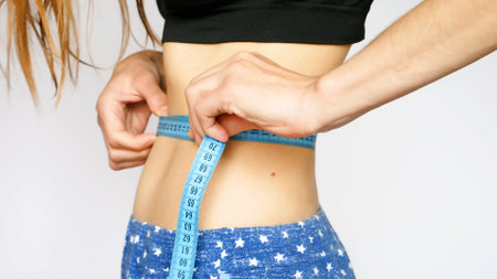 A beautiful girl measures the waistの写真素材