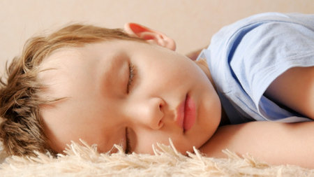 Close-up of a sleeping boy's face on a soft plaidの写真素材