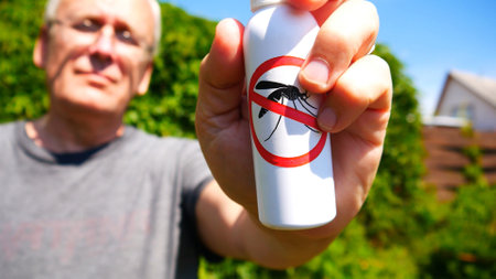 Close-up of anti mosquito spray in the hand of an elderly man staying outdoorsの写真素材