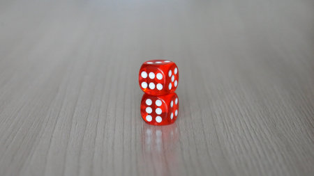 Two beautiful red dices on a wooden surface