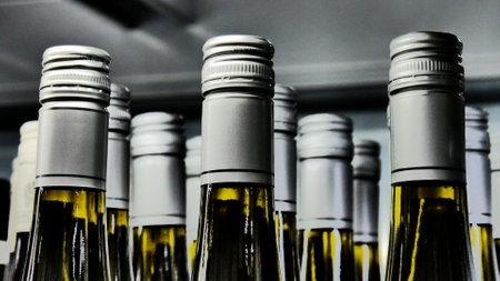 Close-up of many beautiful glass bottles of alcohol drink with silver capsの写真素材