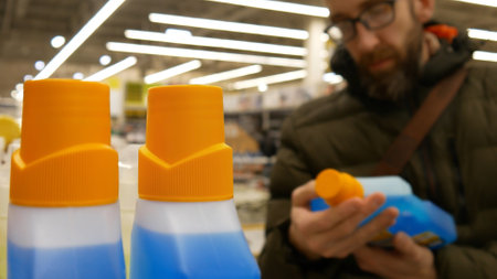 Close-up of detergent or solvent bottles in a hardware store and a buyer chooses oneの写真素材