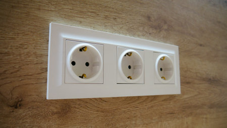 Close-up of EU standard triple outlet in a wooden wall