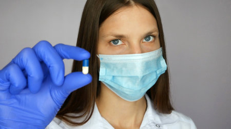 Close up of a female doctor holding out a medicine in her hand