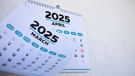 Close-up of a tear off March 2025 page of a wall calendar followed by the next one with the marked date of Easterの写真素材