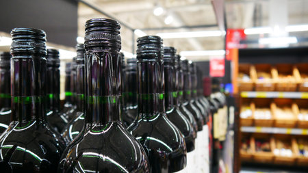Close-up of many gloss black bottle of wine standing on a retail displayの写真素材