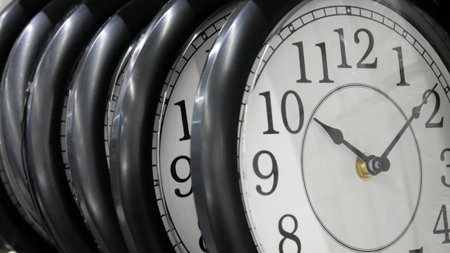 Many wall clocks in a row