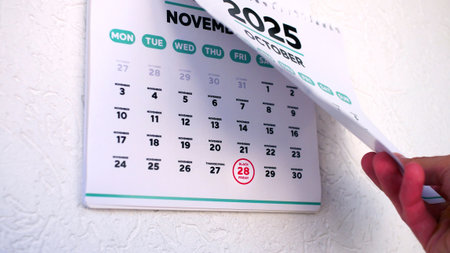 A hand tearing off the calendar page followed by November one with the date of Black Friday 2025の写真素材