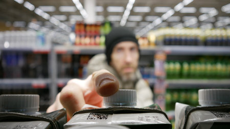 Close-up of a customer's hand taking a carton box of juice or wine from a retail displayの写真素材