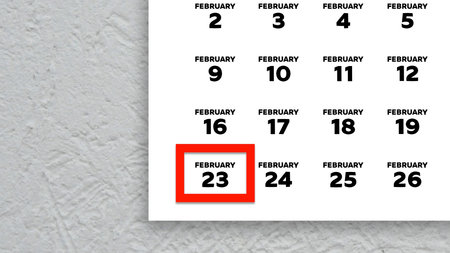 Close-up of the date February 23rd marked with a red cursor on the wall calendar 2026