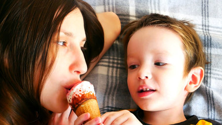A young brunette and a little boy eating an ice cream cone