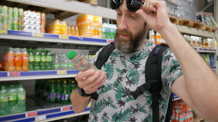 A male customer choosing refreshing drink in a grocery storeの写真素材