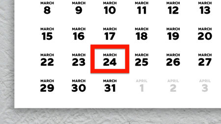 Close-up of the date March 24th marked with a red cursor on the wall calendar 2026
