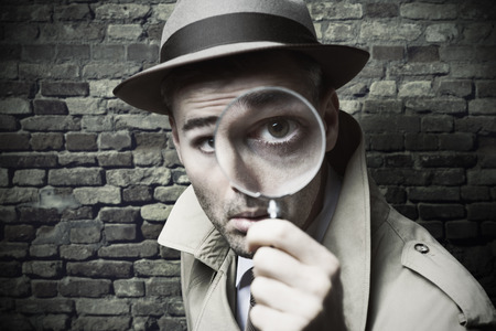Funny vintage detective looking through a magnifierの写真素材