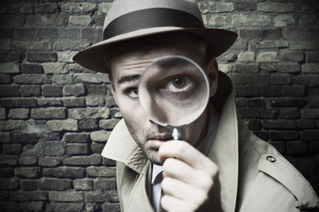 Funny vintage detective looking through a magnifier