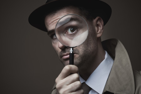 Funny vintage detective looking through a magnifierの写真素材