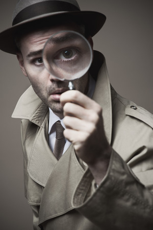 Funny vintage detective looking through a magnifierの写真素材