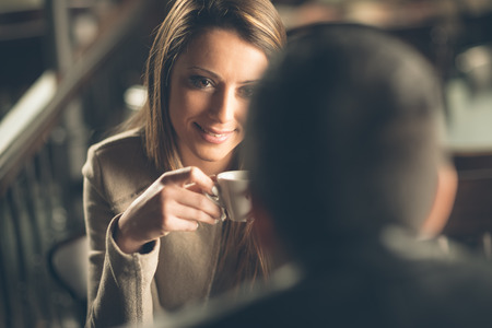 Young fashionable couple dating at the bar, she is having a coffeeの写真素材