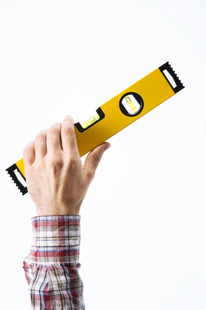 Male carpenter's hand holding a yellow level on white background