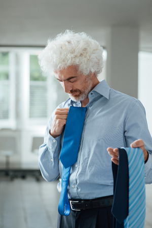 Businessman holding a lot of neckties, outfit color matching and male fashion conceptの写真素材