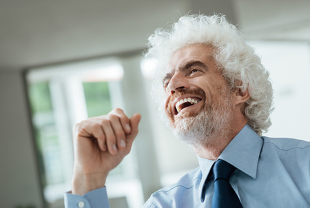 Cheerful smiling businessman looking away and laughingの写真素材