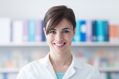 Smiling young doctor posing and looking at camera, healthcare professionalsの写真素材