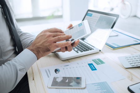 Professional businessman working at desk and using a touch screen tablet, technology and communication conceptの写真素材